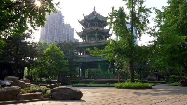 Chengdu, Sichuan, China. Walking in the Wangjiang Pavilion Park lit by warm rays of sun. Wangjiang Tower (Wangjiang Pavilion) and beautiful green flora are seen in the background. 4K