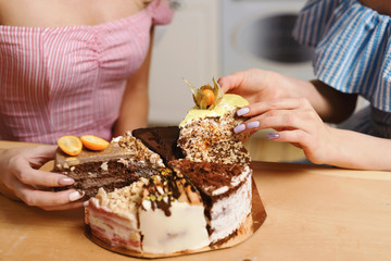 Two beautiful ladies have birthday or hen party. Best girlfriends eating tasty cake. Sisters laughing, taking photos on their smartphones and celebrating holiday. Friendship and food fetish concept.