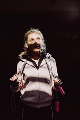 Girl works out with jumping rope. Woman in active wear. Sporty girl tying up her hair.