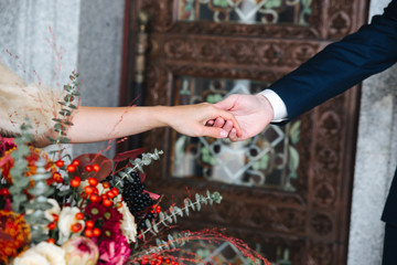 Fototapeta na wymiar Close-up of groom's hand holding bride's hand wirst tender