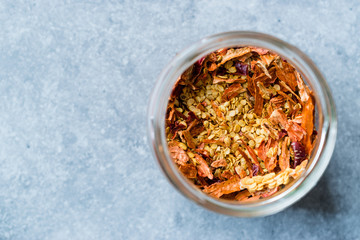 Dried Chili Pepper Flakes and Seeds in Glass Bowl.