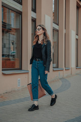 Happy girl with a Hollywood smile and glasses, walking in a park at sunset