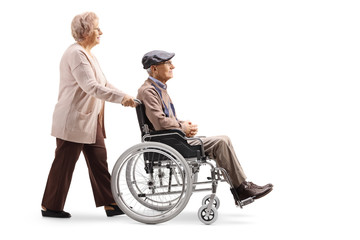 Elderly woman pushing an elderly man in a wheelchair
