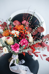 Bridal wedding bouquet with roses and other flowers on tha arm chair