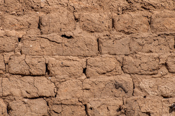 Unreliable, fragile old, clay masonry. Vintage light brown background, texture.