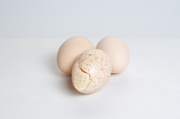 A few eggs on a white background. Broken Spotted Egg.