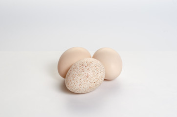 A few eggs on a white background. Broken Spotted Egg.