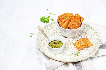 A bowl with crispy cheese crackers on white background