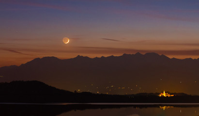 Cielo, luna e pianeti al tramonto sul lago