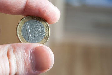 hand with 1 euro coin