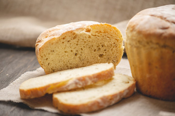 Homemade natural fresh bread with a Golden crust on a napkin on an old wooden background . Baking bakery products