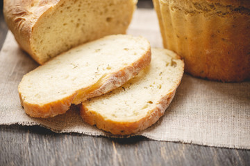 Homemade natural fresh bread with a Golden crust on a napkin on an old wooden background . Baking bakery products