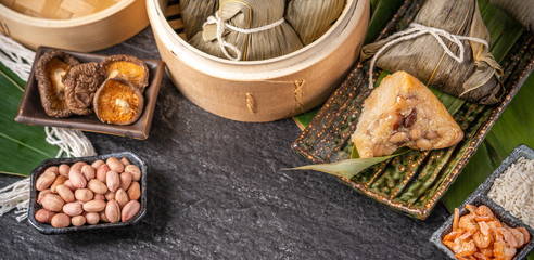 Close up, copy space, top view, famous asian chinese tasty handmade food in dragon boat(duan wu) festival, steamed rice dumplings shaped pyramidal by leaves ingredients