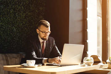Young handsome businessman conducting negotiations with investors. Electronic business. Alternative...