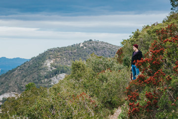 Fototapeta na wymiar Young hipster photographer enjoys mountain range views in Spain rural area