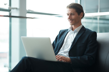 Young handsome businessman conducting negotiations with investors. Electronic business. Alternative...