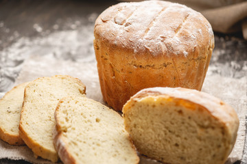 Homemade natural fresh bread with a Golden crust on a napkin on an old wooden background . Baking bakery products