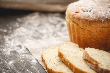 Homemade natural fresh bread with a Golden crust on a napkin on an old wooden background . Baking bakery products