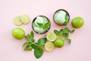 Lime ice cream with mint. Ice cream in wooden bowls on a light pink background