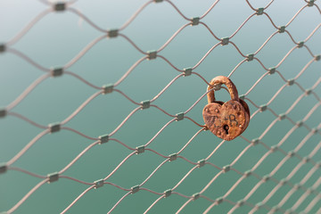old rusty padlock on a fence