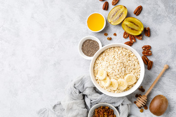 Oat flakes with fruits, nuts and honey in bowl