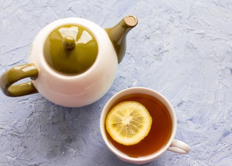 green tea with lemon and kettle on the table