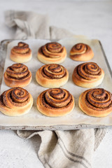 Homemade cinnamon buns on a baking sheet. Delicious cinnamon rolls