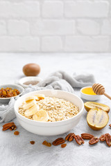Oat flakes with fruits, nuts and honey in bowl