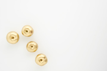 Obraz premium A group of seven gold painted metallic paint apples on a white background.