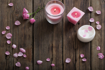 cosmetic mask and burning candle on old wooden background