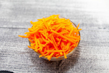 Grated carrot. Carrots grated with straw in a glass Cup.