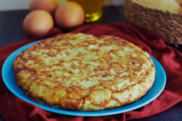 Spanish omelette with potato, egg and onion, accompanied by olive oil
