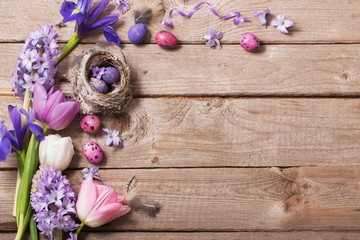 Easter eggs with spring flowers on wooden background