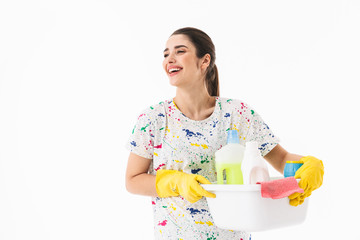 Photo of gorgeous housewife 20s wearing yellow rubber gloves holding bucket with cleaning supplies