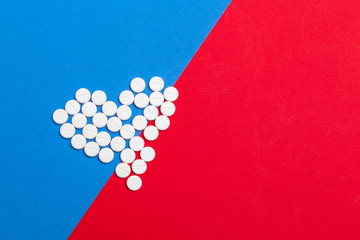 White medical pills on a two color red and blue background