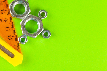 Engineering tools. Bolts and nuts on green background