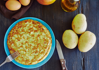 Spanish omelette with potato, egg and onion, accompanied by olive oil