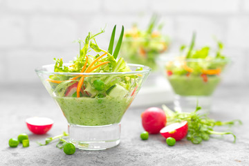 Fresh vegan vegetable salad with carrot, lettuce, green peas, radish, sprouts and cucumber smoothie