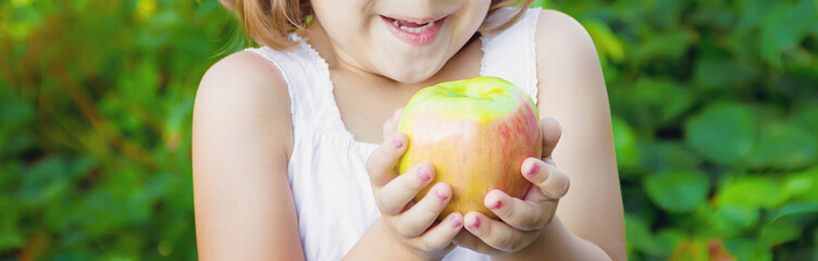 Child with an apple. Selective focus. nature