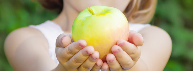 Child with an apple. Selective focus. nature