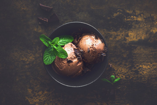 Dark chocolate ice cream in a black bowl, view from above