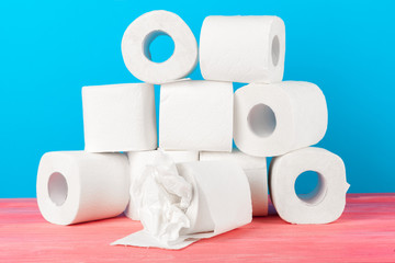 Toilet paper rolls stacked against blue background