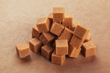 Brown cane sugar cubes on a light brown background
