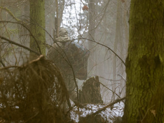 Special Forces in the early spring in the misty forest