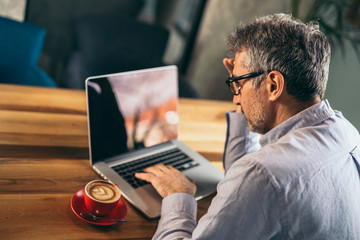 busy businessman using laptop in cafe bar