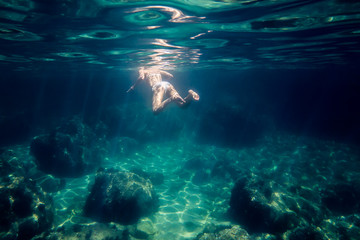 Fototapeta na wymiar underwater view of a woman swimming relaxed at sea