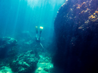Fototapeta na wymiar Man dives to the bottom of sea near the coast