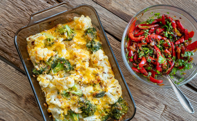 Fried  red pepper and eggplant with Casserole from cabbage, brocoli and cheese on wood deck.