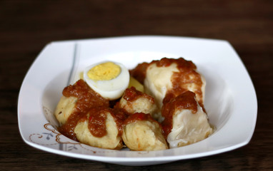 Siomay (fish cake dumplings) and peanut sauce on wood background. 