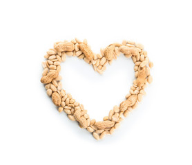 Heart-shaped frame made of tasty peanuts on white background